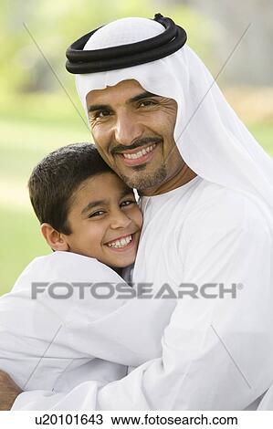 Man and young boy outdoors in park embracing and smiling (selective focus) View Large Photo Image Stock Image - Man and young boy outdoors in park embracing and smiling (selective focus). Fotosearch