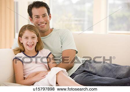 Man and young girl in living room smiling View Large Photo Image Stock Photo - Man and young girl in living room smiling. Fotosearch