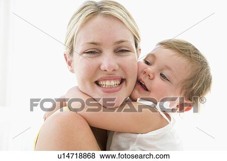 Mother and baby indoors hugging and smiling View Large Photo Image Stock Photo - Mother and baby indoors hugging and smiling. Fotosearch