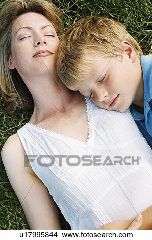 Picture - Mother and son lying outdoors sleeping. Fotosearch