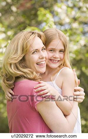 Mother holding daughter outdoors smiling View Large Photo Image Stock Image - Mother holding daughter outdoors smiling. Fotosearch
