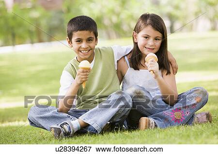 Two young children outdoors in park with ice cream smiling (selective focus) View Large Photo Image Stock Photo - Two young children outdoors in park with ice cream smiling (selective focus). Fotosearch