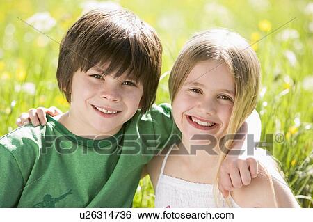 Two young children sitting outdoors arm in arm smiling View Large Photo Image Stock Photograph - Two young children sitting outdoors arm in arm smiling. Fotosearch
