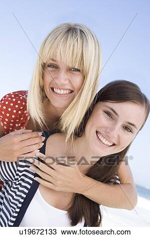 Two young women posing outdoors View Large Photo Image Stock Image - Two young women posing outdoors. Fotosearch