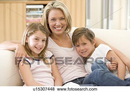 Woman and two young children in living room smiling View Large Photo Image Stock Photo - Woman and two young children in living room smiling. Fotosearch