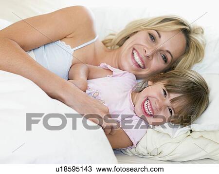 Woman and young girl in bed smiling View Large Photo Image Stock Image - Woman and young girl in bed smiling. Fotosearch