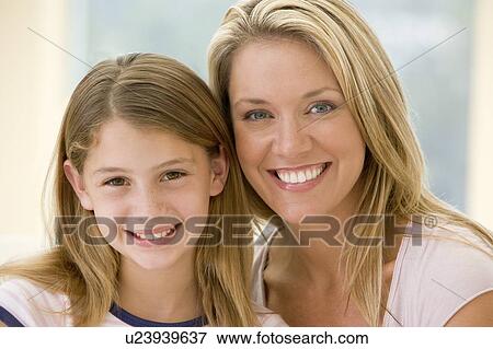 Woman and young girl in living room smiling View Large Photo Image Stock Photo - Woman and young girl in living room smiling. Fotosearch