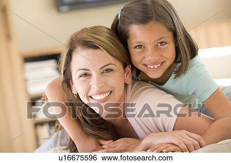 Woman and young girl in living room smiling View Large Photo Image Stock Photograph - Woman and young girl in living room smiling. Fotosearch