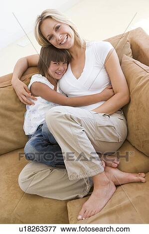 Woman and young girl sitting in living room smiling View Large Photo Image Stock Photo - Woman and young girl sitting in living room smiling. Fotosearch