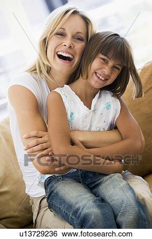 Woman and young girl sitting in living room smiling View Large Photo Image Stock Photograph - Woman and young girl sitting in living room smiling. Fotosearch