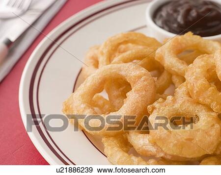 Stock Photo - Battered Onion Rings worth Barbeque Sauce. Fotosearch