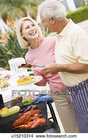 Couple Cooking On A Barbeque View Large Photo Image Picture - Couple Cooking On A Barbeque. Fotosearch