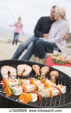 Stock Photo - Couple Cooking On A Barbeque. Fotosearch