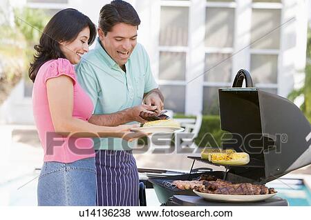 Stock Photo - Couple Cooking On A Barbeque. Fotosearch