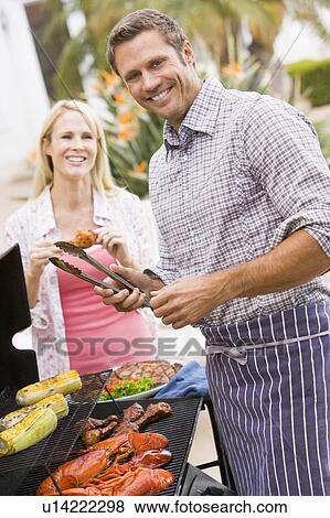 Stock Photo - Couple Cooking On A Barbeque. Fotosearch