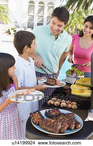 Picture - Family Enjoying A Barbeque. Fotosearch