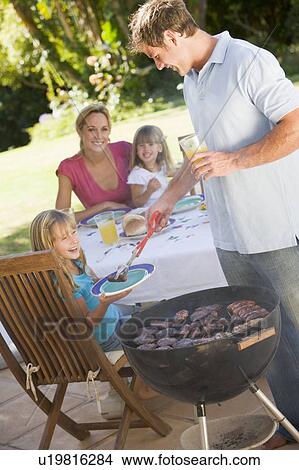 Picture - Family Enjoying A Barbeque. Fotosearch