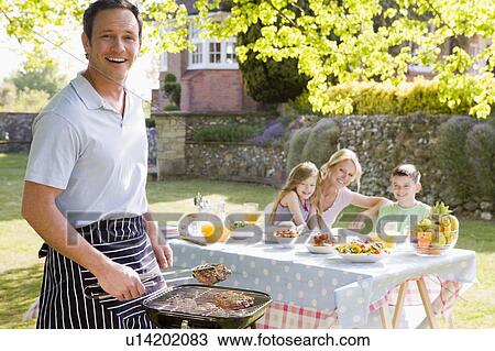 Stock Image - Family Enjoying A Barbeque. Fotosearch