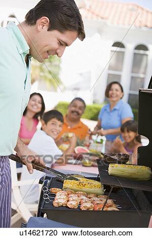 Stock Image - Family Enjoying A Barbeque. Fotosearch