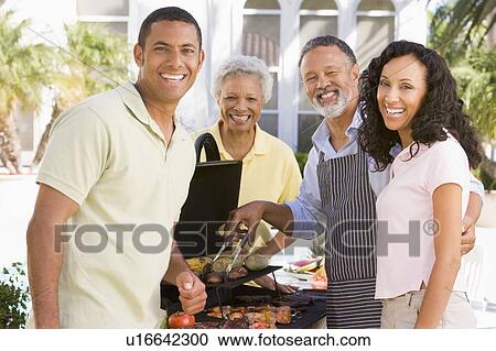 Stock Image - Family Enjoying A Barbeque. Fotosearch