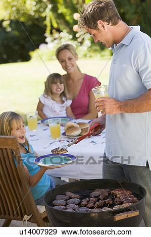 Stock Photo - Family Enjoying A Barbeque. Fotosearch