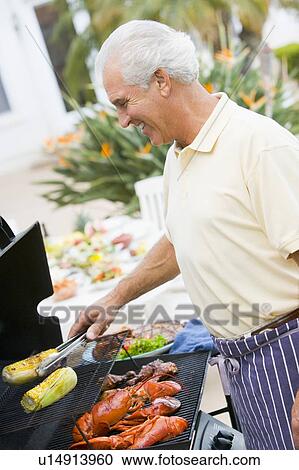Stock Image - Man Barbequing In A Garden. Fotosearch
