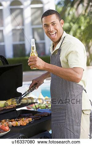 Stock Image - Man Barbequing In A Garden. Fotosearch