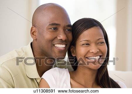 Couple in living room smiling View Large Photo Image Stock Image - Couple in living room smiling. Fotosearch