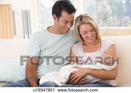 Couple in living room with baby smiling View Large Photo Image Stock Image - Couple in living room with baby smiling. Fotosearch