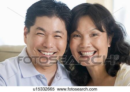 Couple relaxing in living room and smiling View Large Photo Image Stock Photography - Couple relaxing in living room and smiling. Fotosearch