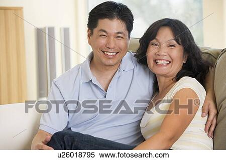 Couple relaxing in living room and smiling View Large Photo Image Stock Photography - Couple relaxing in living room and smiling. Fotosearch