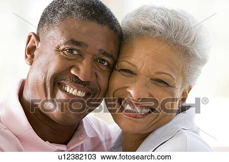 Couple relaxing indoors and smiling View Large Photo Image Stock Image - Couple relaxing indoors and smiling. Fotosearch