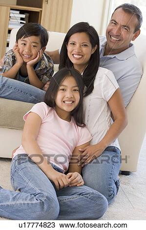 Family in living room smiling View Large Photo Image Stock Image - Family in living room smiling. Fotosearch