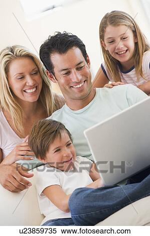 Family in living room with laptop smiling View Large Photo Image Stock Photography - Family in living room with laptop smiling. Fotosearch