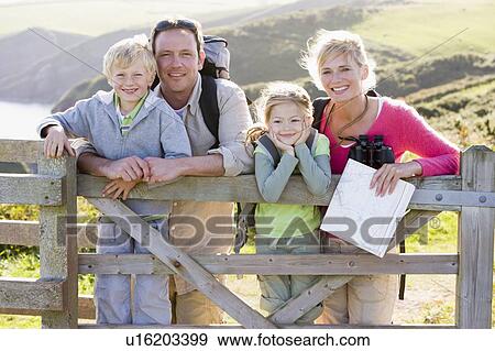 Family on cliffside path leaning on fence and smiling View Large Photo Image Stock Photo - Family on cliffside path leaning on fence and smiling. Fotosearch