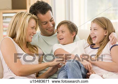 Family sitting in living room smiling View Large Photo Image Stock Image - Family sitting in living room smiling. Fotosearch