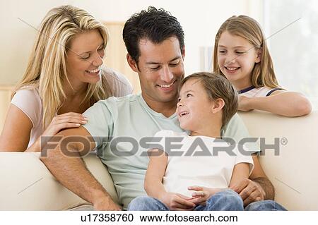 Family sitting in living room smiling View Large Photo Image Stock Image - Family sitting in living room smiling. Fotosearch