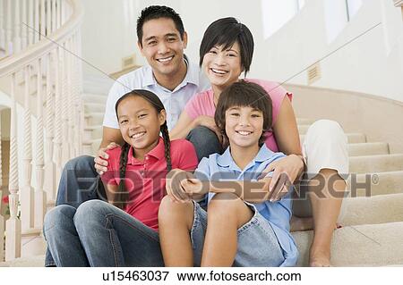 Stock Photo - Family sitting on staircase smiling. Fotosearch