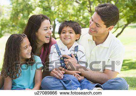 Stock Photograph - Family sitting outdoors smiling. Fotosearch