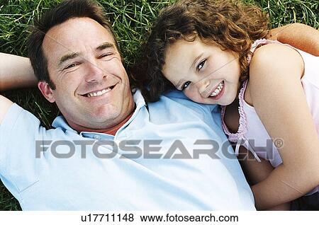 Father and daughter lying outdoors smiling View Large Photo Image Stock Photo - Father and daughter lying outdoors smiling. Fotosearch
