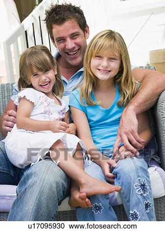 Man and two young girls sitting on patio smiling View Large Photo Image Stock Image - Man and two young girls sitting on patio smiling. Fotosearch