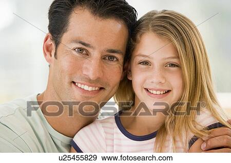 Man and young girl in living room smiling View Large Photo Image Stock Photo - Man and young girl in living room smiling. Fotosearch