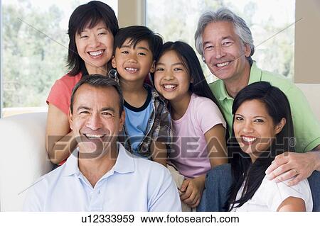 Stock Photo - Extended family in living room smiling. Fotosearch