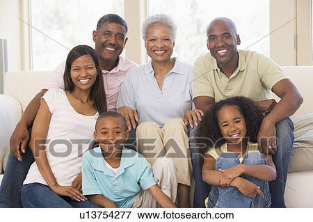 Stock Photo - Extended family in living room smiling. Fotosearch