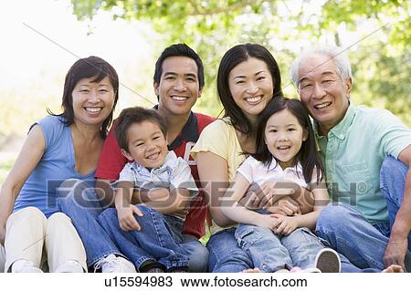 Extended family sitting outdoors smiling View Large Photo Image Stock Image - Extended family sitting outdoors smiling. Fotosearch