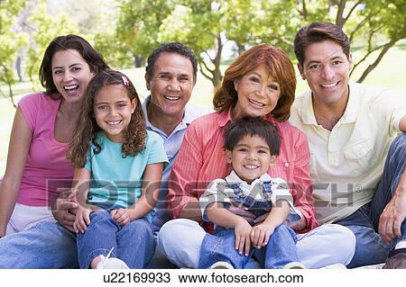 Extended family sitting outdoors smiling View Large Photo Image Stock Image - Extended family sitting outdoors smiling. Fotosearch