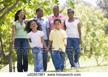 Extended family walking in park holding hands and smiling View Large Photo Image Stock Image - Extended family walking in park holding hands and smiling. Fotosearch