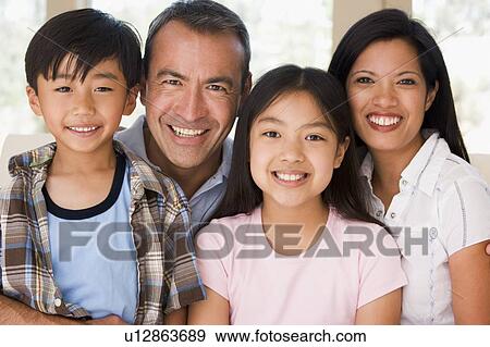 Family in living room smiling View Large Photo Image Stock Photo - Family in living room smiling. Fotosearch