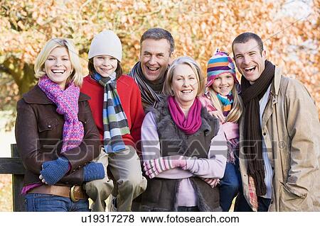 Stock Photo - Family outdoors in park smiling (selective focus). Fotosearch