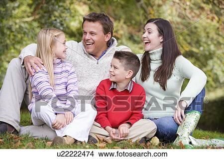 Family sitting outdoors laughing (selective focus) View Large Photo Image Picture - Family sitting outdoors laughing (selective focus). Fotosearch